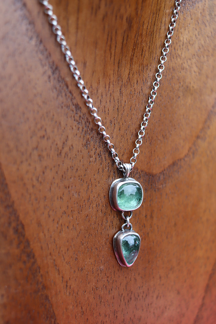 Necklace with blue/green gemstones on a wooden surface